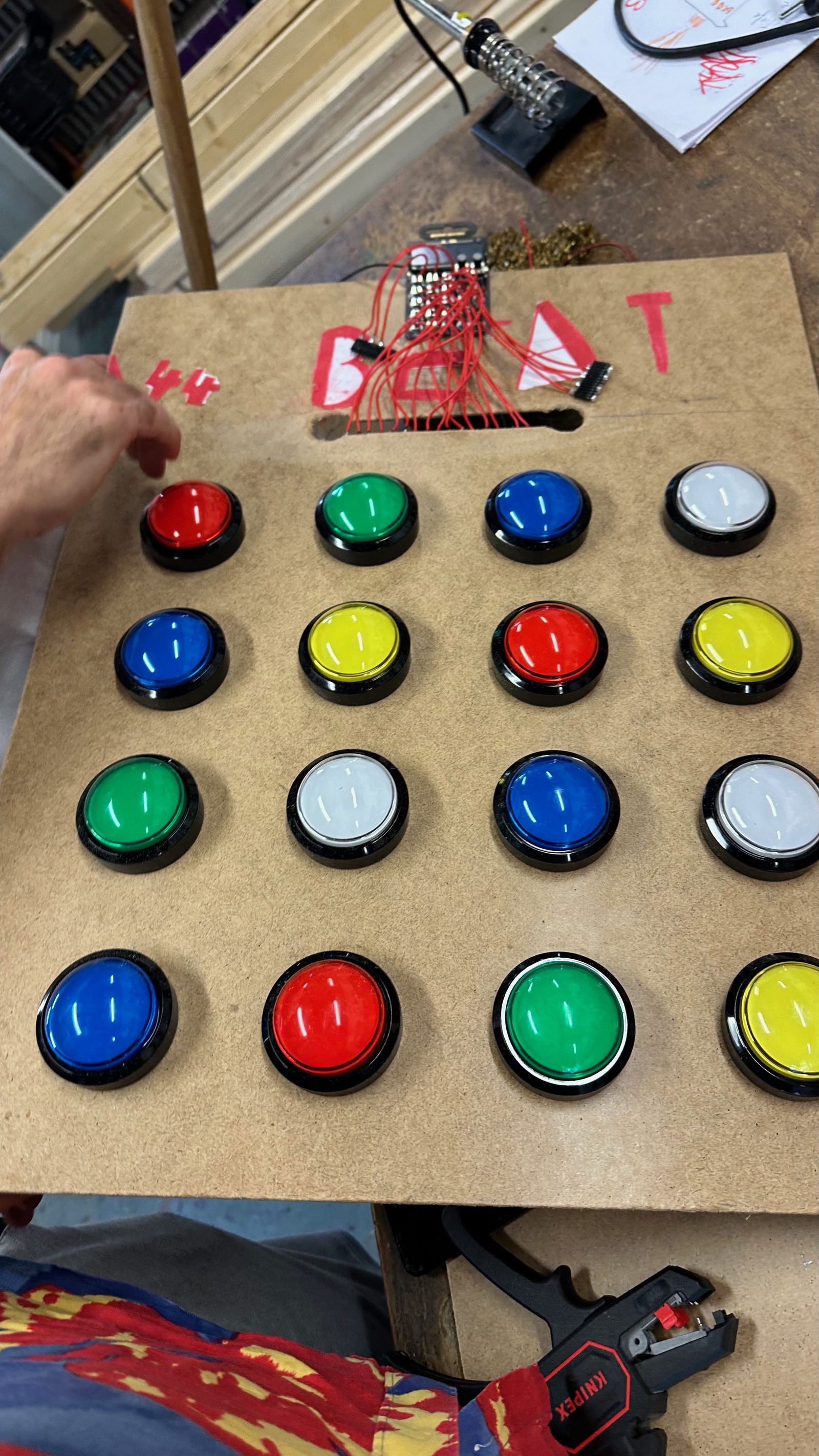 Sixteen arcade buttons on the build board, wiring behind them