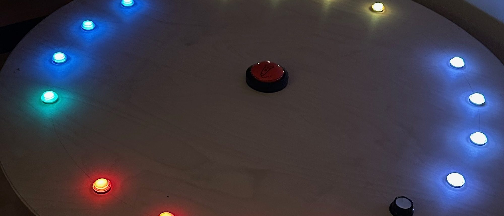 The round table with a ring of coloured lights, in the dark