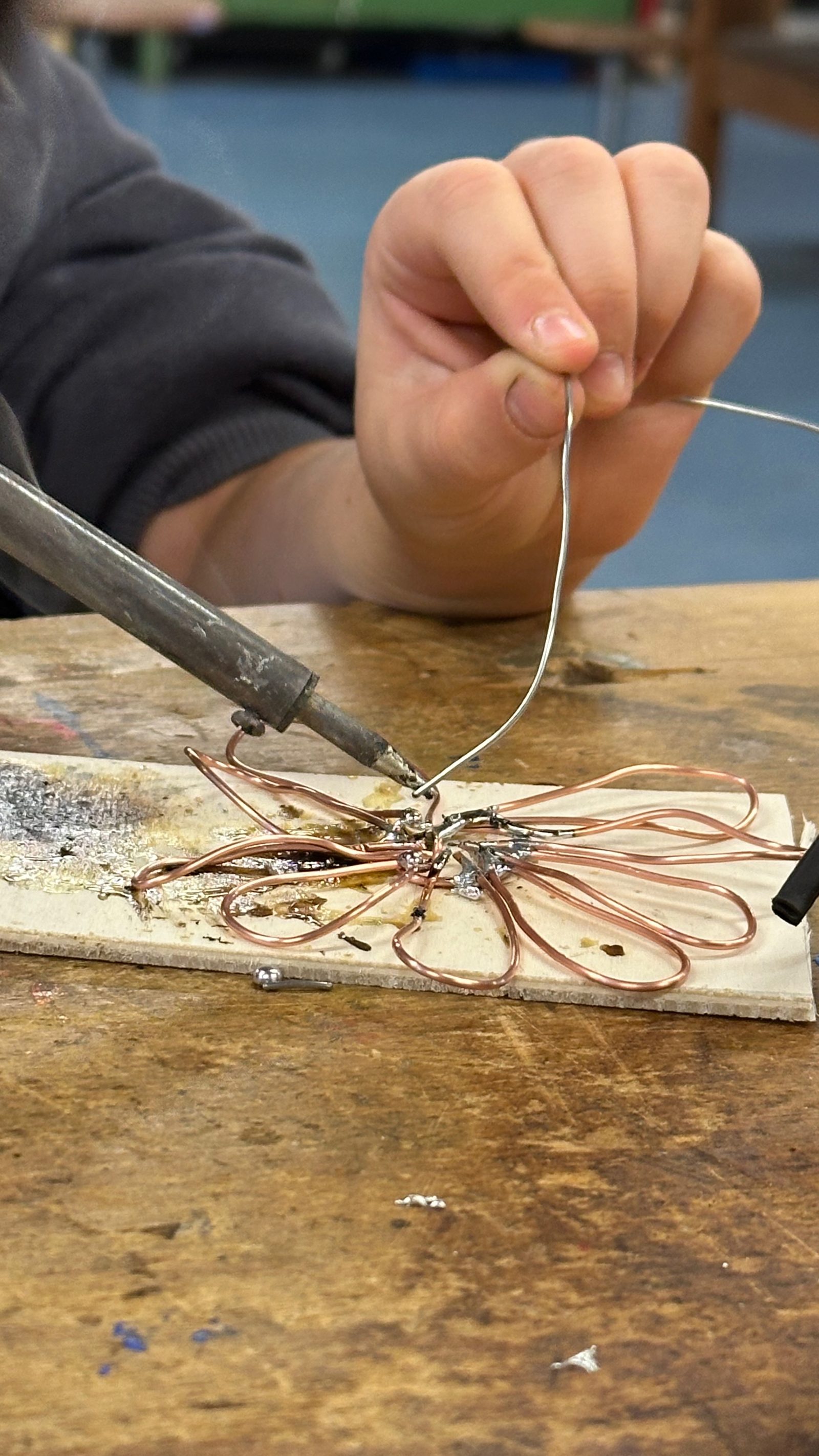 A hand guiding solder onto a joint