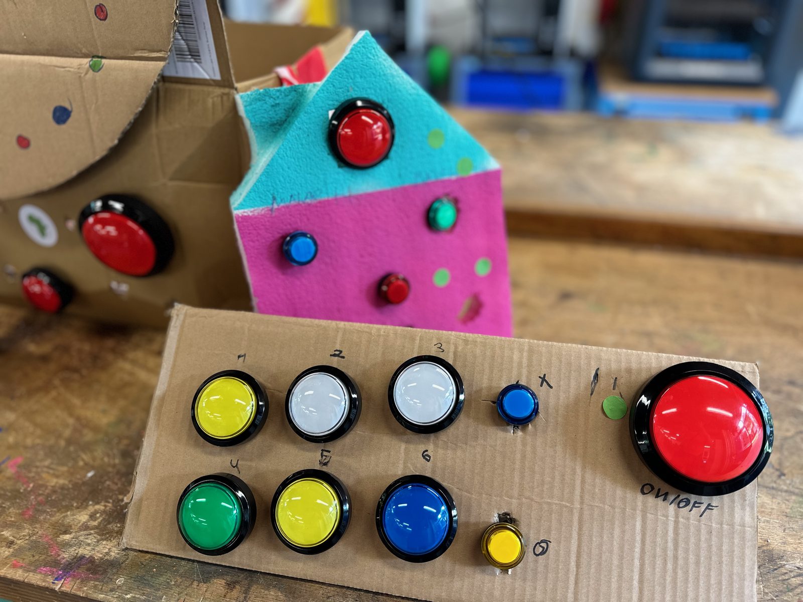 A control panel made of cardboard, next to a self-built little house