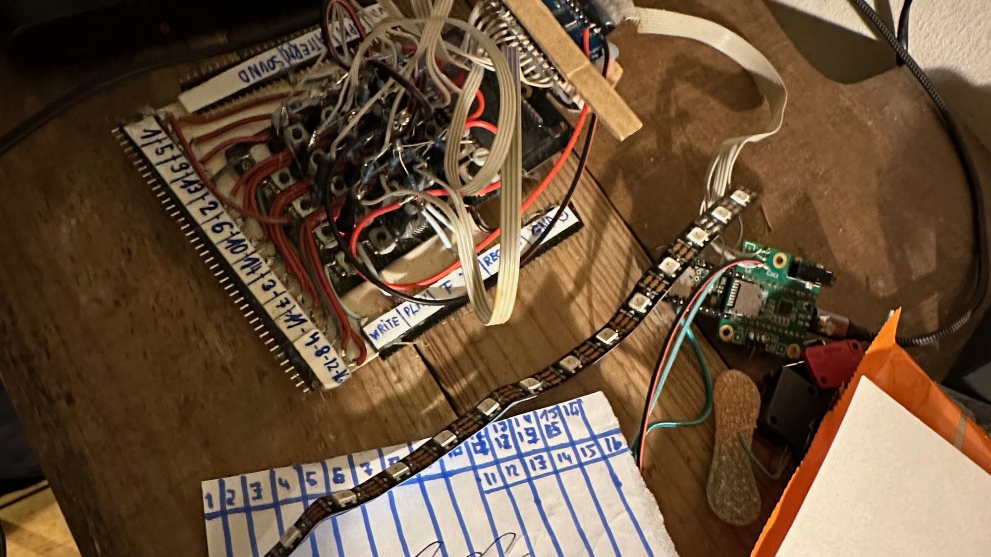 Wiring, notes and a laptop on the workbench — the development behind it